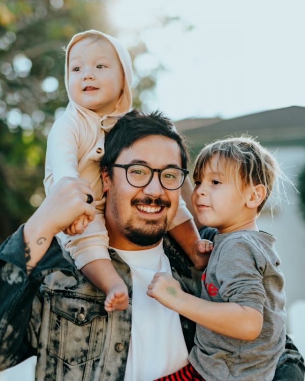 Un padre sonriente comparte tiempo al aire libre con sus hijos